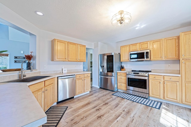 kitchen featuring a sink, light brown cabinets, and stainless steel appliances