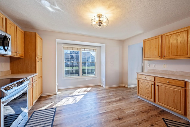 kitchen with light countertops, light wood-type flooring, and stainless steel appliances