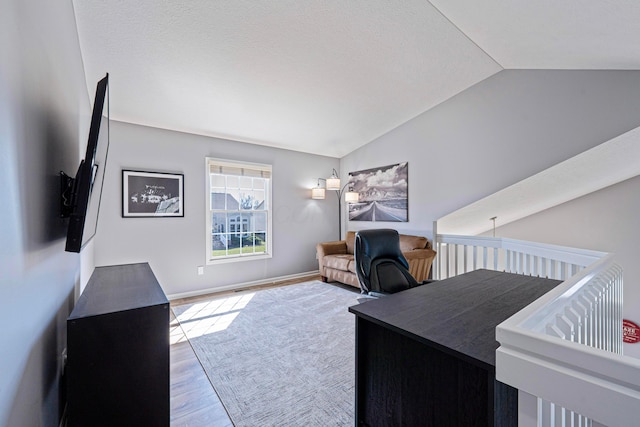 office featuring baseboards, lofted ceiling, and wood finished floors