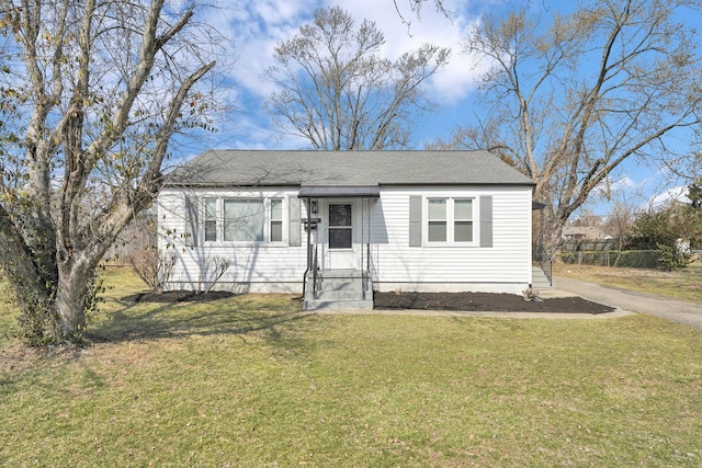 bungalow-style house featuring driveway, a front yard, and a shingled roof