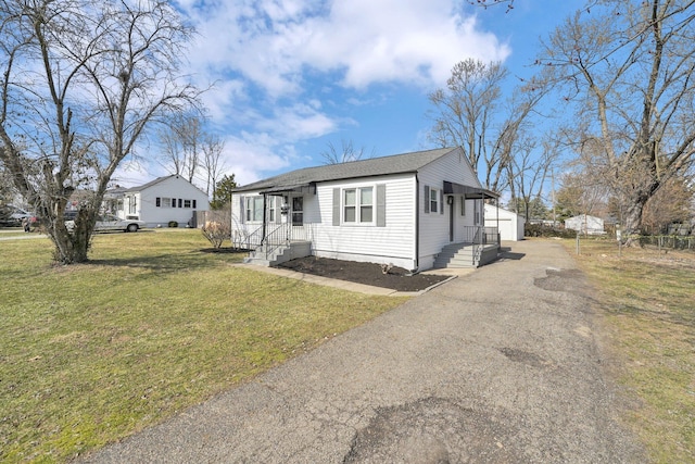 view of front of home featuring a front lawn and an outbuilding