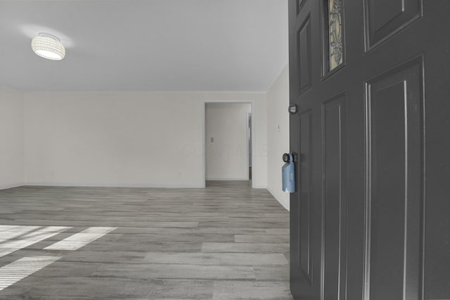 unfurnished room featuring light wood-type flooring and baseboards