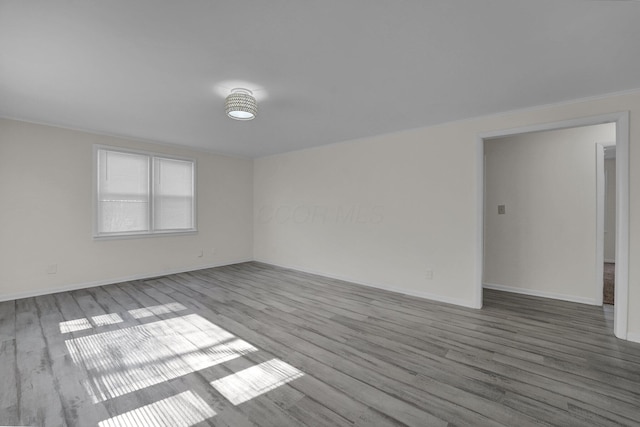 unfurnished room with wood finished floors and baseboards