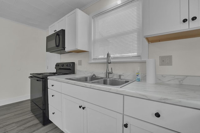 kitchen with white cabinetry, black appliances, crown molding, and a sink