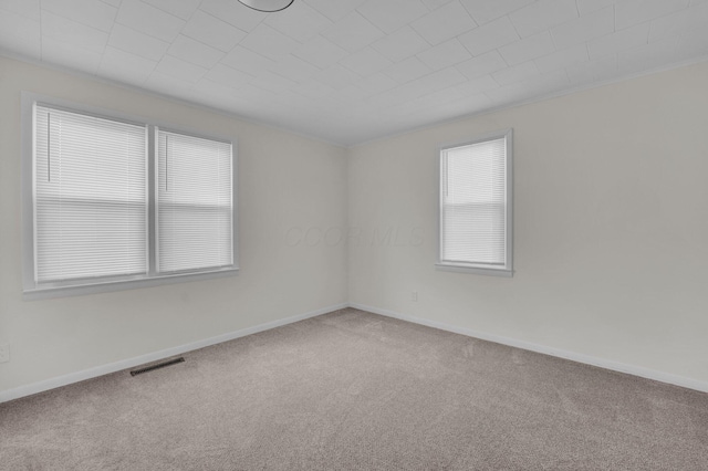 empty room featuring visible vents, baseboards, and carpet floors