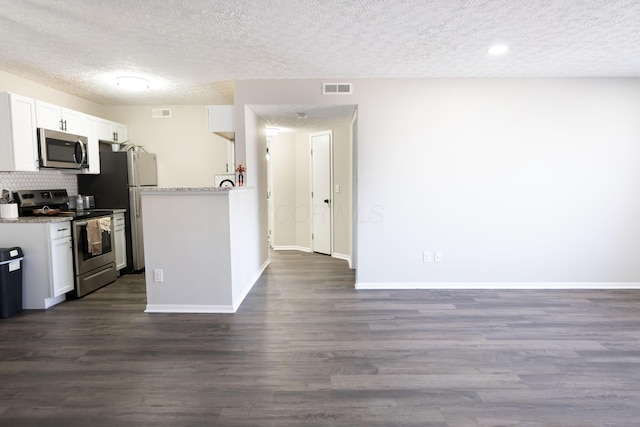 kitchen with visible vents, dark wood finished floors, appliances with stainless steel finishes, decorative backsplash, and baseboards