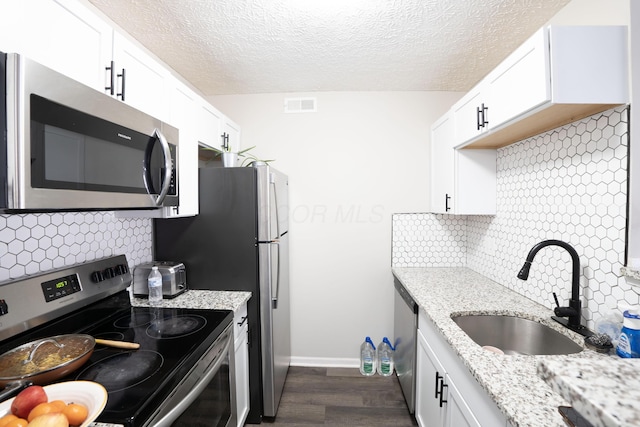 kitchen with visible vents, appliances with stainless steel finishes, white cabinetry, and a sink