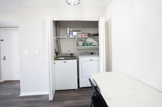 laundry area featuring baseboards, dark wood finished floors, laundry area, a textured ceiling, and washing machine and dryer