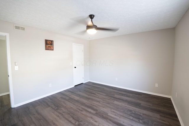 spare room with visible vents, baseboards, a ceiling fan, and dark wood-style flooring