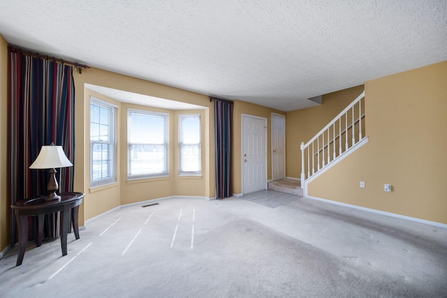 living area with baseboards, carpet floors, and a textured ceiling