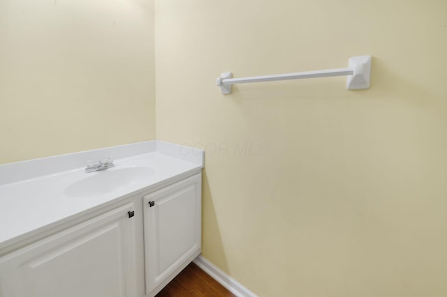 bathroom with vanity, baseboards, and wood finished floors