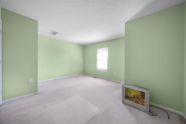 unfurnished room with heating unit, visible vents, baseboards, a textured ceiling, and carpet flooring