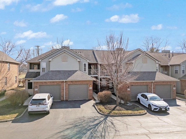 view of front of property with brick siding, aphalt driveway, and roof with shingles