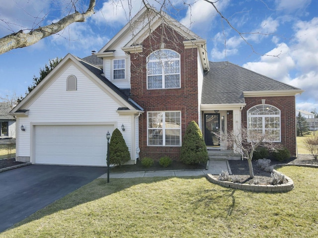 traditional-style home with driveway, an attached garage, a shingled roof, a front lawn, and brick siding