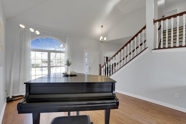 interior space featuring stairway, lofted ceiling, baseboards, and wood finished floors