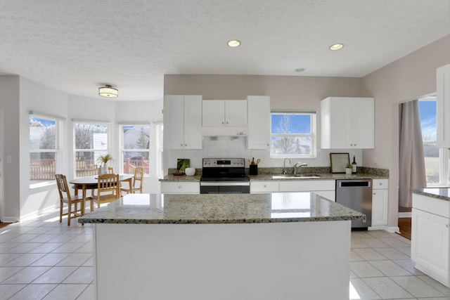 kitchen with light tile patterned floors, a healthy amount of sunlight, stainless steel appliances, and a sink