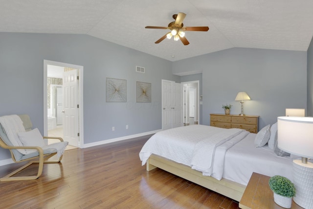 bedroom with visible vents, baseboards, lofted ceiling, and wood finished floors