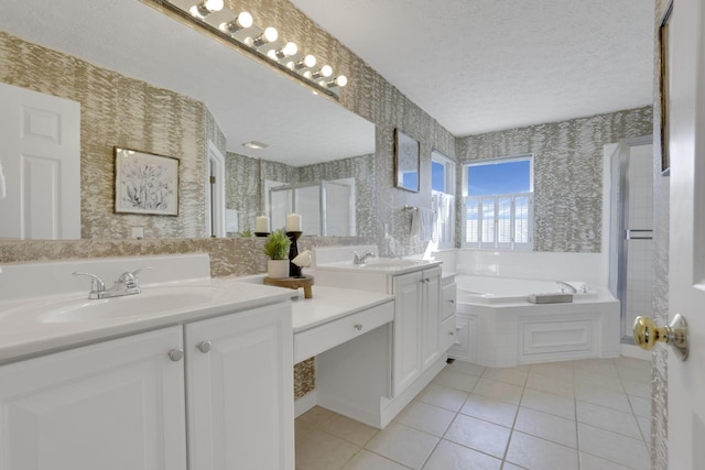 bathroom with a sink, a garden tub, a textured ceiling, and wallpapered walls