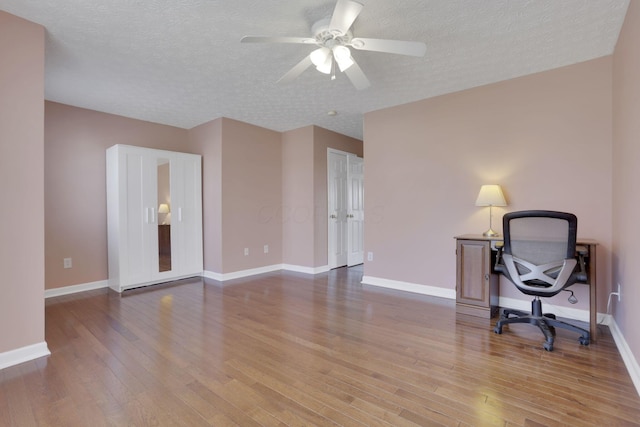 office space with baseboards, a textured ceiling, and wood finished floors