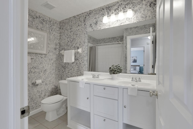 full bath featuring tile patterned floors, toilet, a textured ceiling, and wallpapered walls