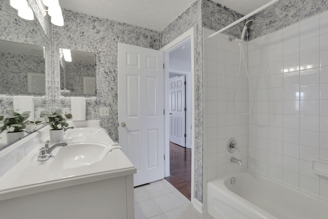 bathroom featuring a textured ceiling, wallpapered walls, shower / bathing tub combination, and a sink