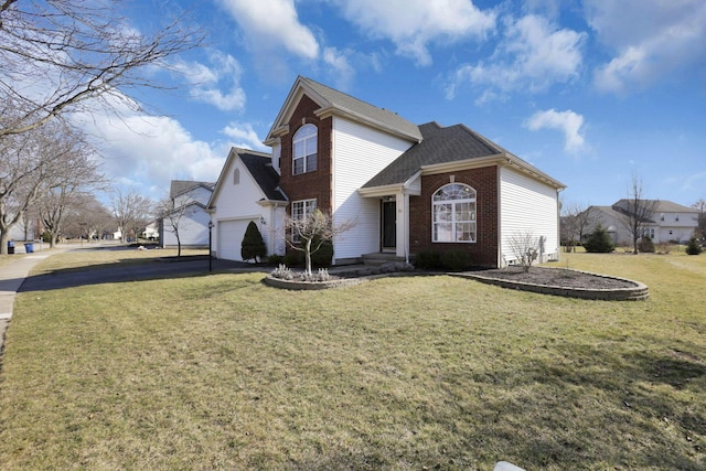 traditional home featuring a garage, brick siding, a front yard, and aphalt driveway