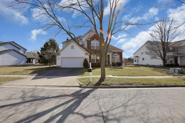 traditional home featuring aphalt driveway, an attached garage, and a front lawn