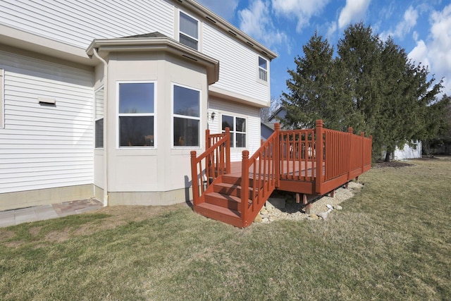 rear view of house featuring a yard and a deck