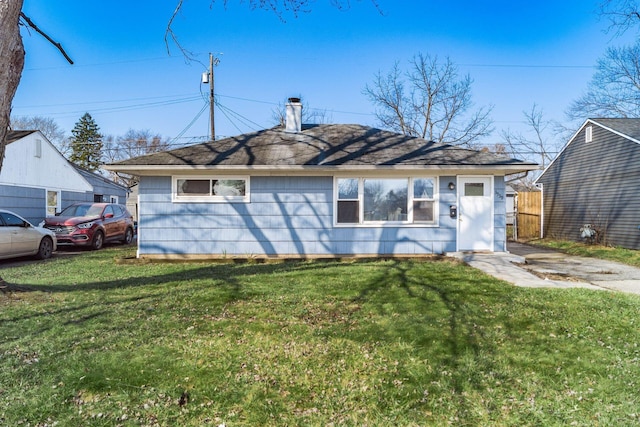 back of property with a lawn and a chimney