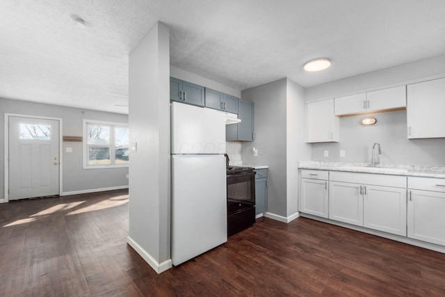 kitchen with a sink, dark wood finished floors, freestanding refrigerator, baseboards, and black range with gas stovetop