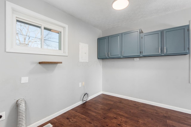 laundry area featuring baseboards, hookup for an electric dryer, cabinet space, dark wood-style flooring, and a textured ceiling