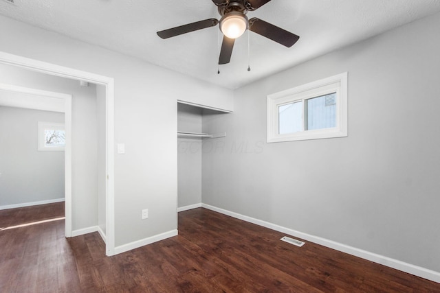 unfurnished bedroom featuring visible vents, a ceiling fan, wood finished floors, a closet, and baseboards