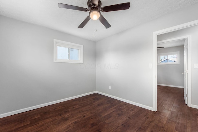 spare room with baseboards, wood finished floors, and a ceiling fan