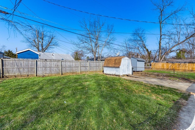 view of yard featuring a storage shed, an outbuilding, and a fenced backyard