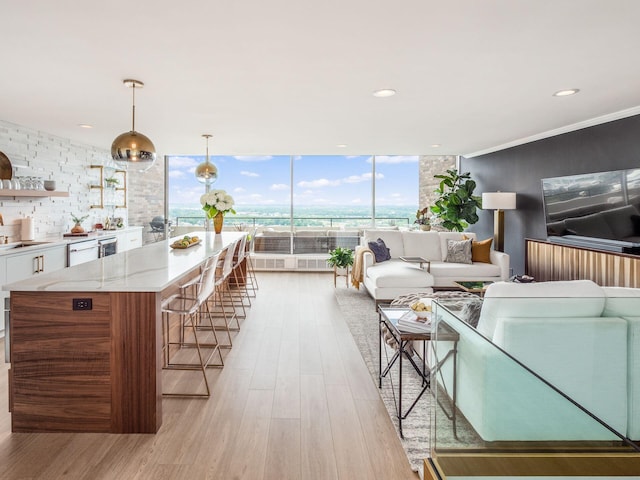 living area with recessed lighting, light wood finished floors, and expansive windows