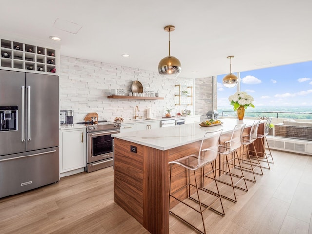 kitchen with open shelves, a sink, light wood-style floors, appliances with stainless steel finishes, and white cabinetry