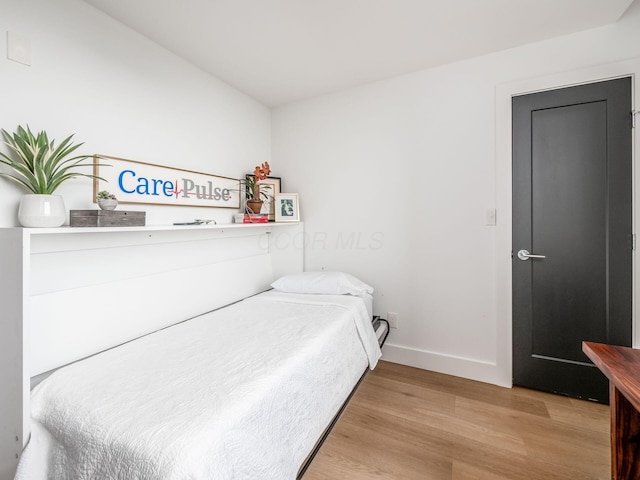 bedroom featuring wood finished floors and baseboards