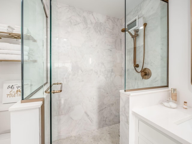 bathroom with a marble finish shower and vanity