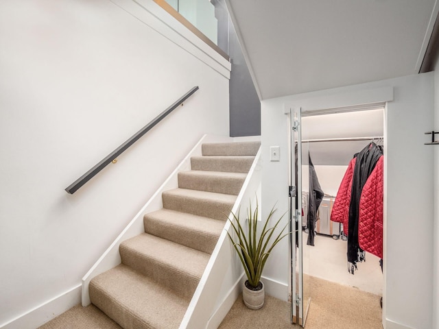 stairs featuring carpet flooring and baseboards