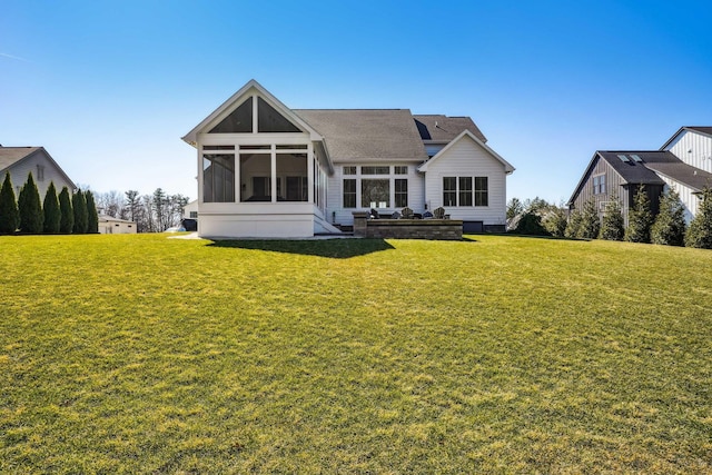 rear view of house featuring a lawn and a sunroom