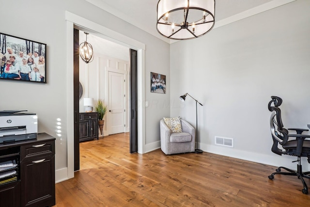 office featuring light wood-type flooring, visible vents, baseboards, and a notable chandelier