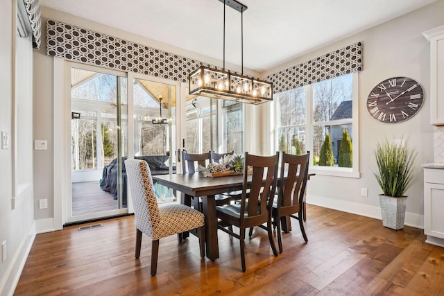 dining area with hardwood / wood-style floors, baseboards, and visible vents