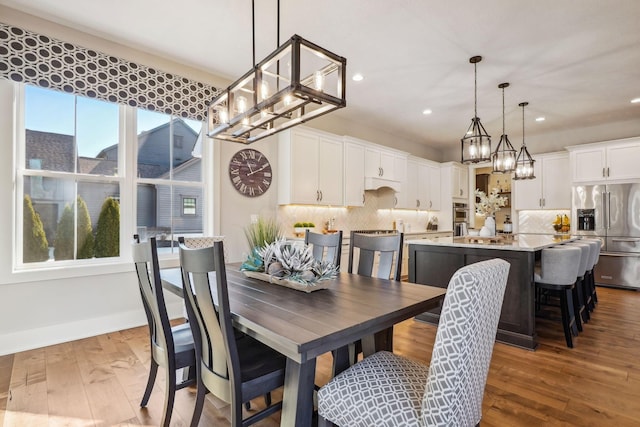 dining room featuring recessed lighting, baseboards, an inviting chandelier, and wood finished floors