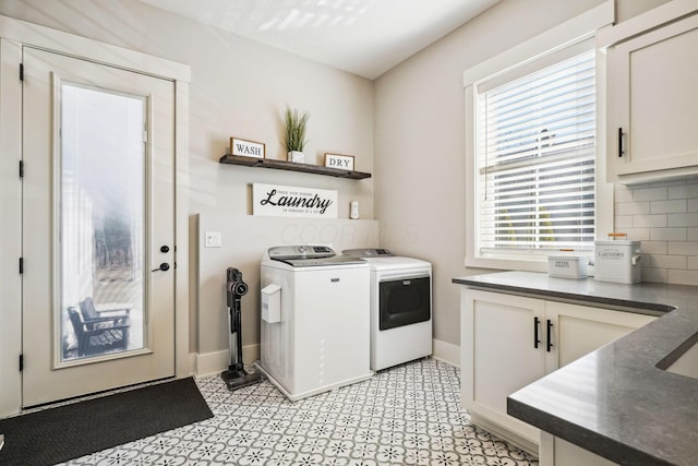 laundry area featuring cabinet space, baseboards, and washer and clothes dryer