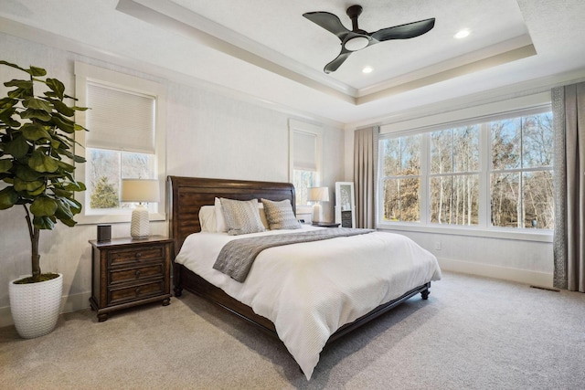 bedroom with visible vents, baseboards, ornamental molding, light carpet, and a raised ceiling