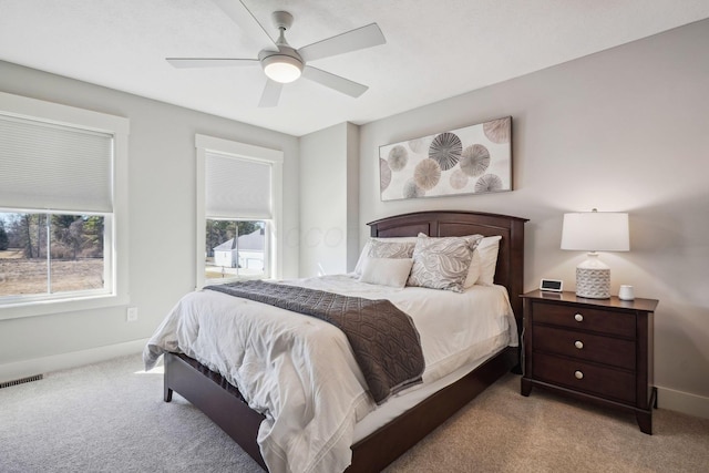 carpeted bedroom with visible vents, ceiling fan, and baseboards