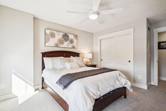 carpeted bedroom featuring a ceiling fan, visible vents, baseboards, and a closet