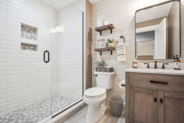 full bath with a stall shower, toilet, vanity, and wood finished floors