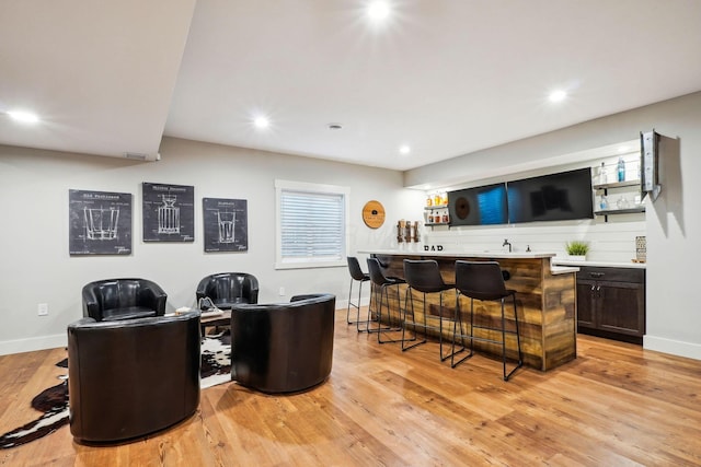 bar with recessed lighting, wet bar, and light wood-type flooring