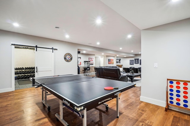 playroom featuring visible vents, recessed lighting, a barn door, light wood-style floors, and baseboards